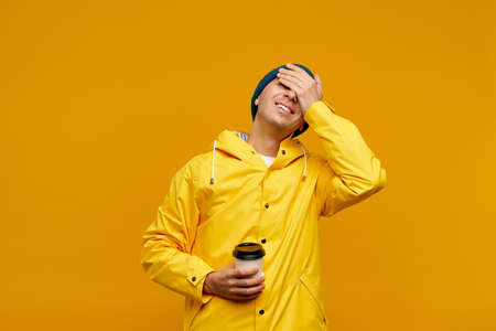 Portrait of positive cool man in warm autumn top outdoor clothes holding coffee