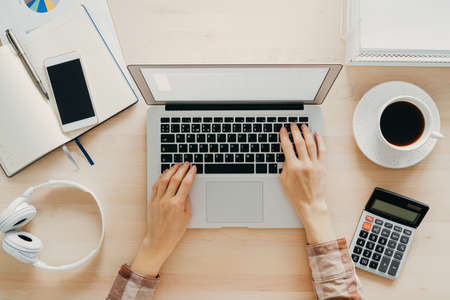 Work from home, online learning. Wooden desk, table. Top view. Distance education. Woman hands...