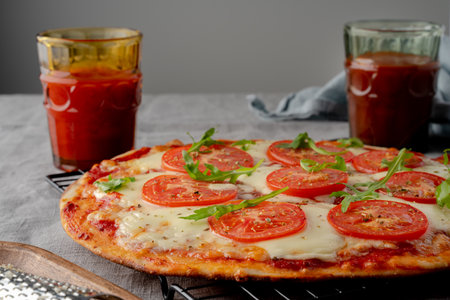 Rustic Italian homemade Pizza Dough margherita topped with pizza sauce from canned tomatoes, mozzarella cheese and arugula on dark linen textile tableclothの写真素材