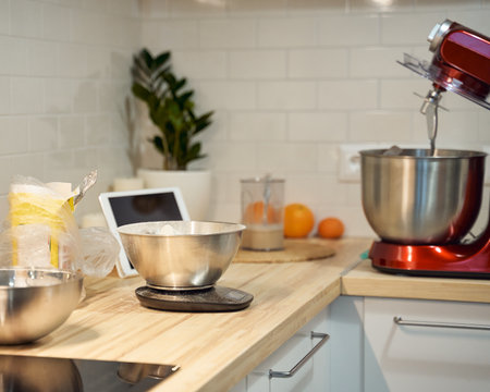 Cooking and baking food kitchen background at home, apartment, flour, scales, bowls, digital tablet with recipes on tableの写真素材