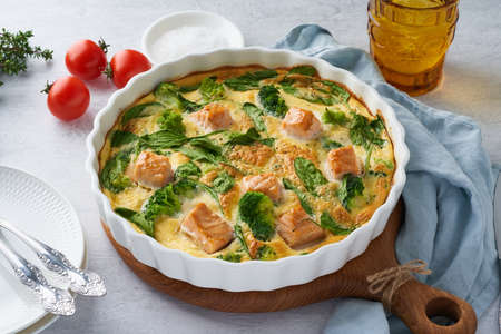 Egg-based frittata, omelette with salmon, broccoli and spinach. Italian dish, crustless quiche with eggs, fish and vegetables. Mediterranean ketogenic healthy dietの写真素材