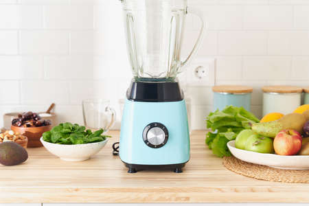 Morning vegan breakfast in blender, making smoothies for detox and proper nutrition from fresh vegetables and fruits. Spinach with avocado and banana, green smoothie drinkの写真素材