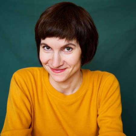 Smiling mature brunette woman looking playful and defiant, close-up face portrait of middle-aged...