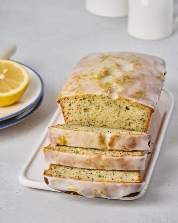 Traditional white glazed lemon bread with poppy seeds and citrus zest. Sliced homemade fruitcake....