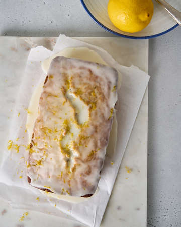 Top view of lemon bread with poppy seeds, white icing and orange zest. Delicious dessert for tea....