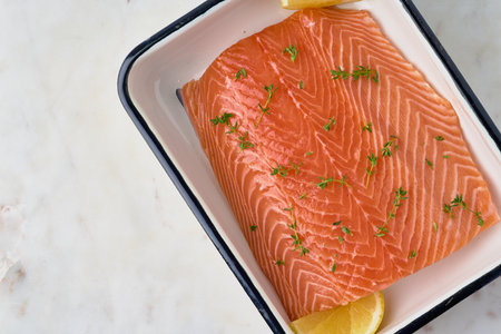 Raw salmon fillet with herbs and lemon. Scandinavian seafood cuisine. Humpback fillet. Fresh seafish meal preparation. Cooking omega and protein dish. Horizontal, copy spaceの写真素材