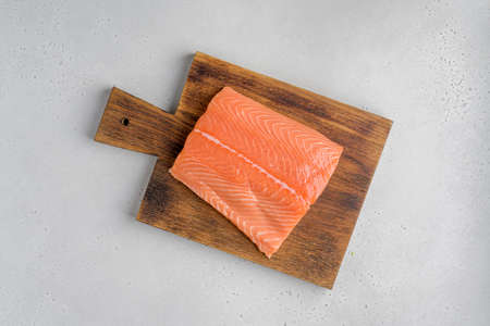 Fresh raw salmon humpback fillet on old wooden board. Horizontal, top viewの写真素材
