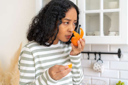 African-american female having post-covid syndrome. Concept of loosing smell due to covid-19 virusの写真素材