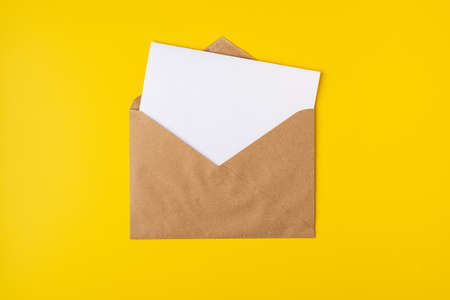 Realistic mockup blank white letter craft paper envelope on yellow backdrop front view, templateの写真素材