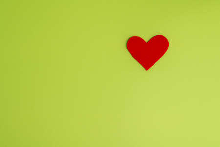 Concept of charity and healthcare donation. Heart symbol of love and romance on green backgroundの写真素材