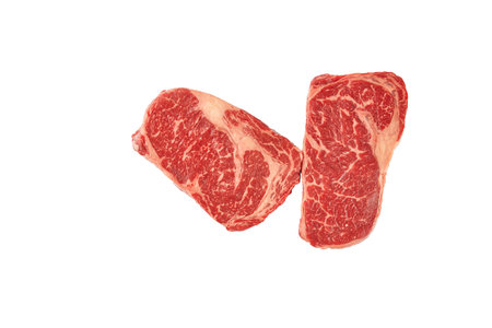 Two raw top blade beef steak isolated on white background. Big marbled whole piece of raw meat, striploin on white. Top view, closeupの写真素材