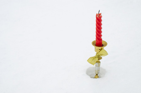 red candle in a posvechnik on snowの写真素材