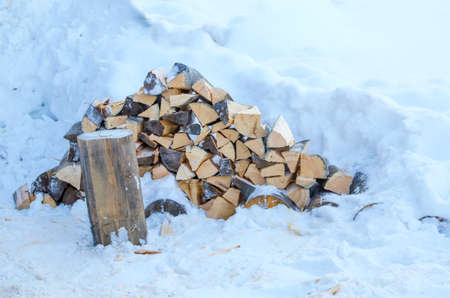 the woodpile of firewood on snow