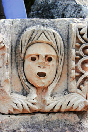 Stone mask cut in a stone. Ruins of Ancient Greek theater.の写真素材
