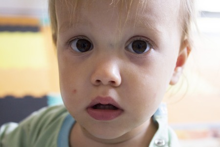 Little serious toddler with big brown eyesの写真素材