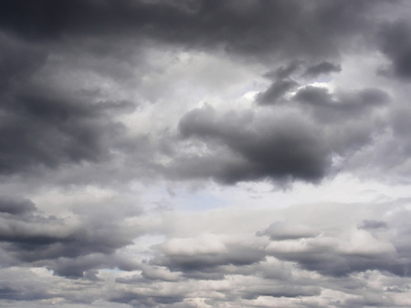 The sky with dark gray clouds and small gaps between them