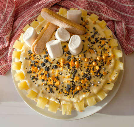 Homemade cream cake garnished with nonparella, marshmallows and pineapple. Top view