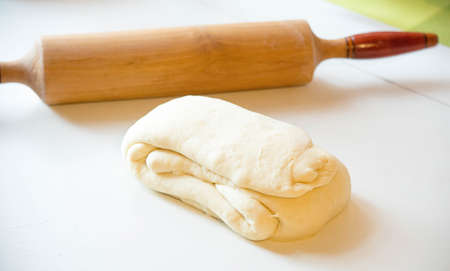 Making yeast puff dough on the table, next to a rolling pin
