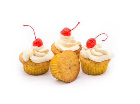 Delicious cupcakes with cream and maraschino cherriesの写真素材