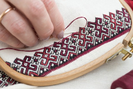 Fragment of embroidery on linen and hands of the masterの写真素材