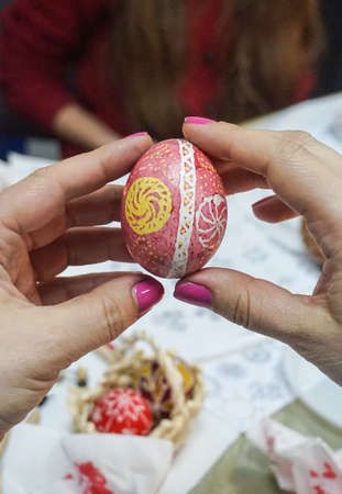 People paint Easter eggs at the table in the room