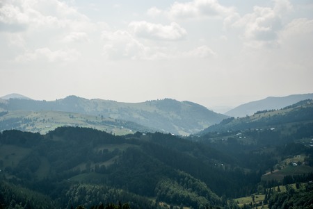 Village in the Carpathian Mountains. In the background, the mountains in the hazeの写真素材