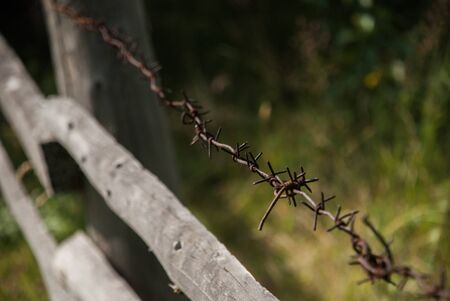 Barbed wire stretched along the wooden fence
