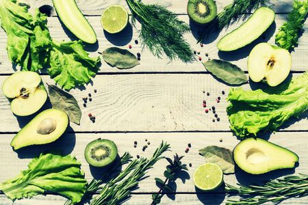 Green fresh vegetables and seasonings on a white wooden table. Tの写真素材