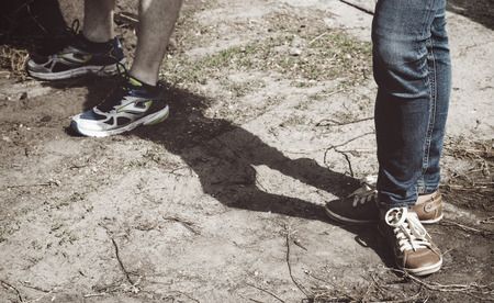 Legs of the girl and the guy in sports shoesの写真素材