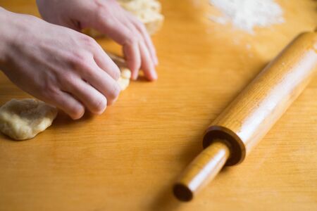 Woman kneading a dough on the tableの写真素材