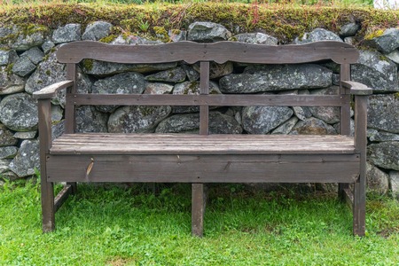 Wooden benches in a park near a stone wallの写真素材