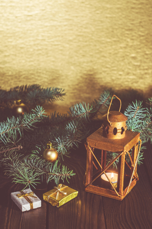 Lantern with candle and Christmas tree branch on a wooden tableの写真素材