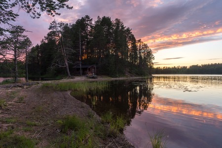 Reflection of trees at colorful sunset in the lakeの写真素材