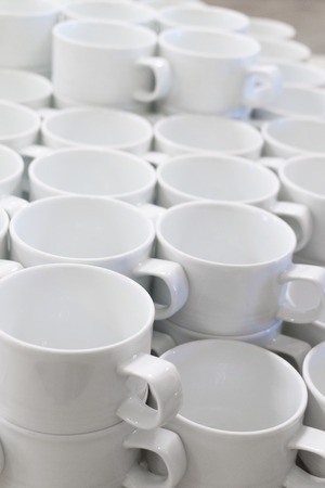 A lot of empty white porcelain cups on the tableの写真素材