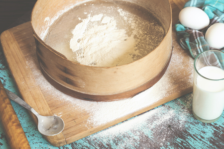Sieve and products for baking on a blue surfaceの写真素材