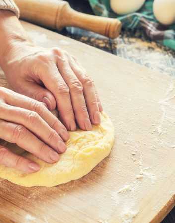 Woman kneading a dough on the tableの写真素材