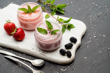 Smoothies of mulberries, strawberries and mint in glass jarsの写真素材