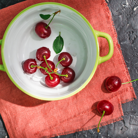Cherries in a ceramic bowl on a dark backgroundの写真素材