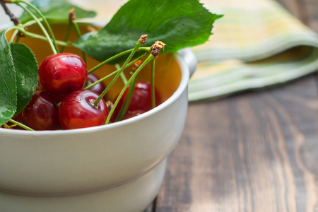 Cherries in a ceramic bowl on a dark backgroundの写真素材