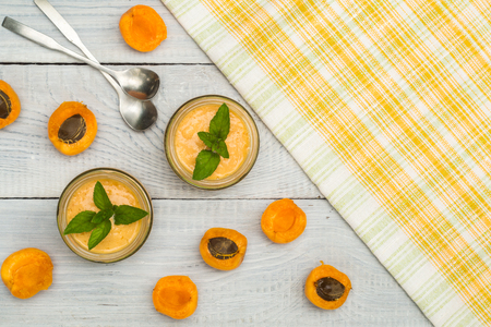 Smoothies of mulberries, apricot and mint in glass jars on white wooden backgroundの写真素材