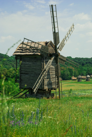 Old wooden windmill in a meadowの写真素材
