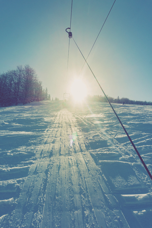 Skiers on a ski lift on a mountain slopeの写真素材