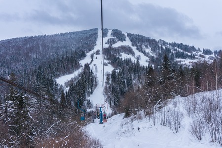 Skiers on a ski lift on a mountain slopeの写真素材