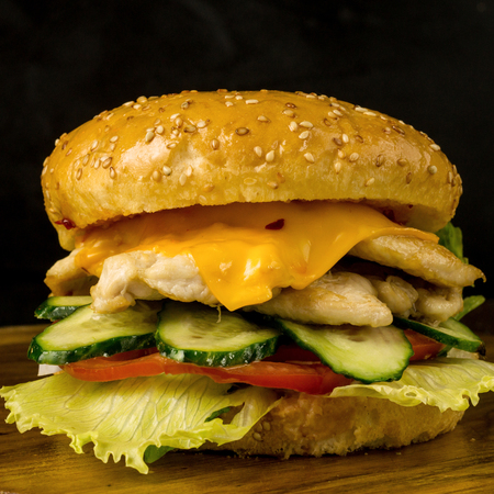 Hamburger with chicken and vegetables on a black backgroundの写真素材