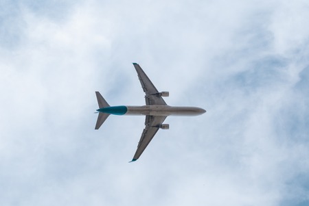White civil airplane in the cloudy skyの写真素材