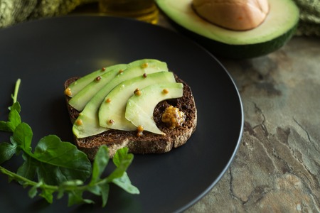 Rye bread with avocado and mustard seeds. Healthy food breakfast concept