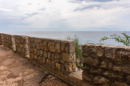 Stone fence on the promenade along the seaの写真素材