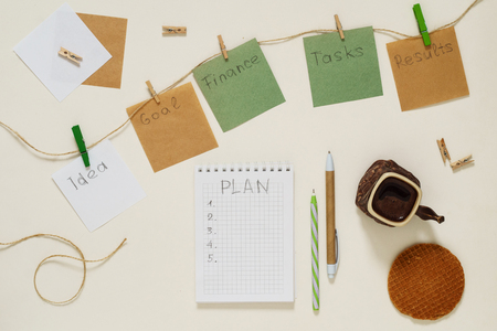 Words Goal, Idea, Tasks, Finance, Results, Plan on paper stickers with clothespins on a rope and notebookの写真素材