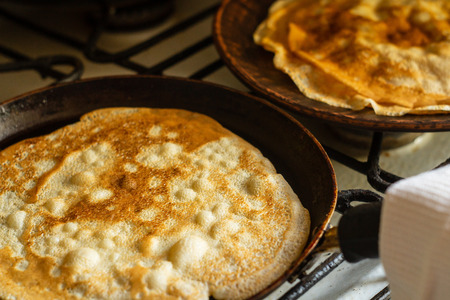 Cooking thin pancakes in a pan on the stove