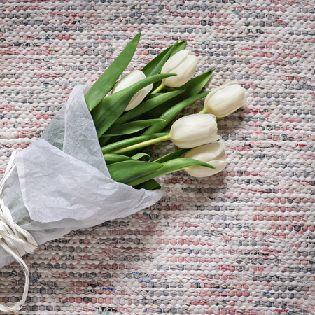 Bouquet of white tulips on rustic textile backgroundの写真素材